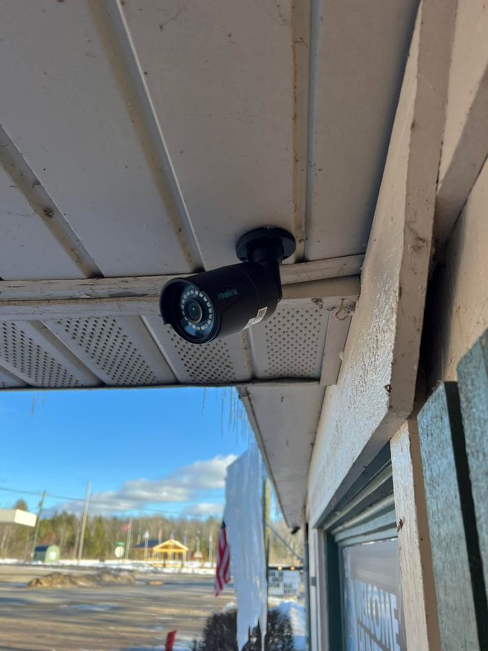 Weatherproof security camera installed under a commercial building eave
